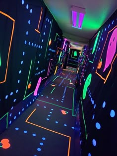 the hallway is lit up with neon lights and black walls that are covered in dots