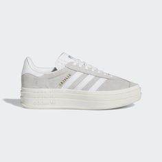 It wouldn't be a list of adidas' most iconic shoes without the Gazelle. First worn on indoor courts in the '70s, the suede shoe is gaining new fans to this day. Now the style you covet is lifted up to new heights. It's stacked three layers high, for a new perspective on the classic style. The details stay sporty with buttery-soft suede and serrated 3-Stripes. A metallic-gold "Gazelle" is the final stamp of our heritage. Cutest Shoes For Teens, Casual Shoes For Women Sneakers, Women’s Adidas Sneakers, Adidas Shoes Women Platform, Trendy Everyday Shoes, 2025 Clothing Trends, Gray Adidas Shoes Outfit, Woman Sneakers Outfit, Trending Adidas Shoes