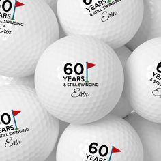 several white golf balls with the 60th anniversary logo on them