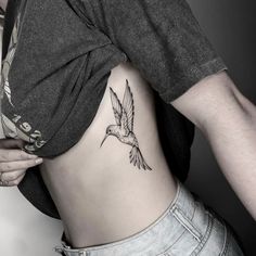 a woman with a bird tattoo on her lower back and the bottom part of her stomach