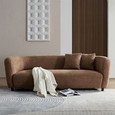 a brown couch sitting on top of a white rug