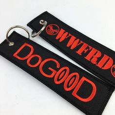 two black and red key chains with the words dogwood printed on them, sitting next to each other