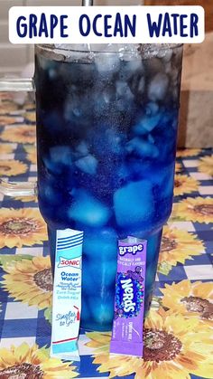 a glass filled with blue liquid sitting on top of a table