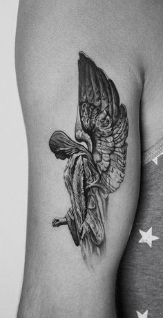 a black and white photo of a woman's arm with a bird tattoo on it