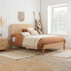 a bed sitting in a bedroom next to a wooden dresser and window on top of a hard wood floor