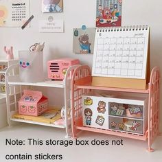 there is a pink toy storage box in the corner with other toys on it and a calendar next to it