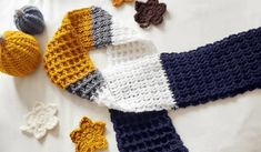 several crocheted hats and mittens laid out on a white tablecloth,