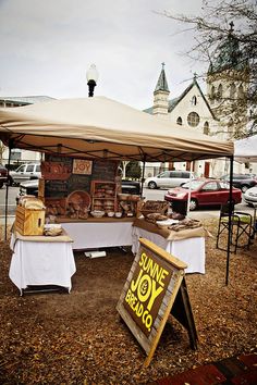 an outdoor market with food on display under a tent