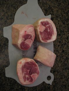 three pieces of meat sitting on top of a cutting board