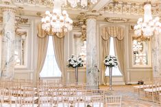 an elegant ballroom with chandeliers and chairs