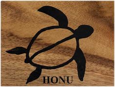 an image of a turtle on wood with the word honu written in black ink