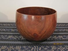 a wooden bowl sitting on top of a rug