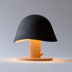 a table lamp with a wooden base and black lampshade on the top, against a gray background