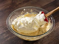 a bowl filled with whipped cream on top of a wooden table