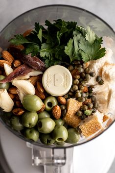 a blender filled with lots of different types of vegetables and nuts on top of it