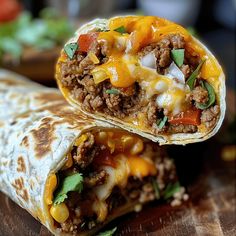 two burritos with meat, cheese and vegetables on them sitting on a cutting board