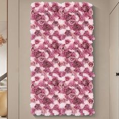 a pink flowered wall hanging on the side of a door in a living room