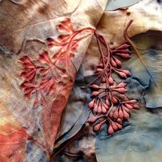 the fabric has been stitched together with flowers and leaves on it, along with other material