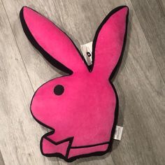 a pink stuffed animal sitting on top of a wooden floor