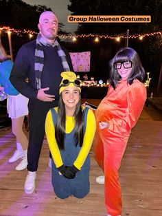 three people dressed in costumes posing for a photo at an outdoor halloween costume party with lights on the background