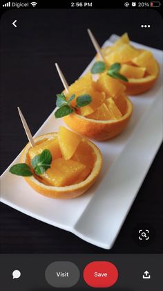 some oranges with toothpicks in them on a white plate