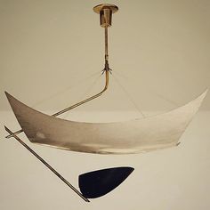 an upside down boat hanging from a light fixture with two oars sticking out of it