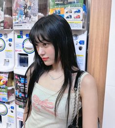 a woman standing in front of a vending machine with her hand on her hip