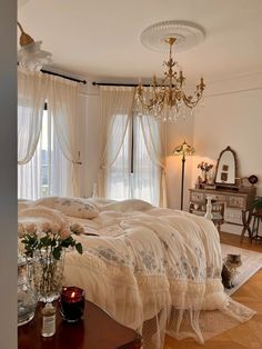 a large bed sitting in a bedroom next to a table with flowers on top of it