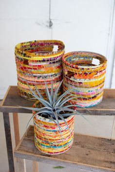 two planters sitting on top of a wooden shelf