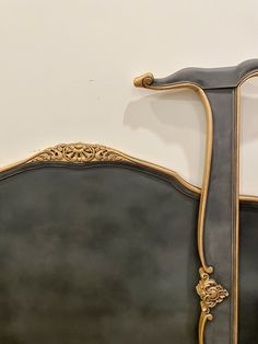 an ornate gold and black headboard against a white wall