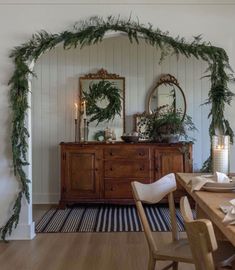 a dining room decorated with greenery and candles