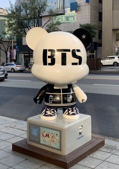 a mickey mouse statue on the sidewalk in front of a building