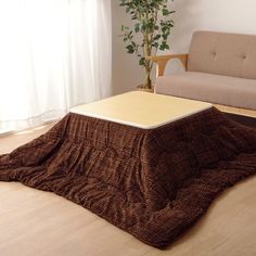 a living room with a couch, coffee table and rug on the floor in front of a window