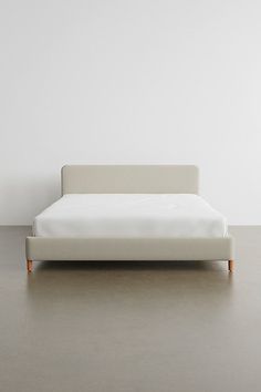 a white bed sitting on top of a wooden floor