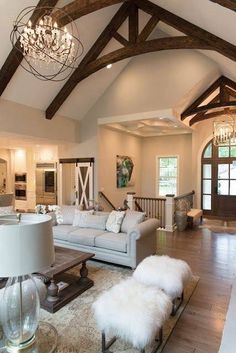 a living room filled with furniture and a chandelier hanging over the top of it