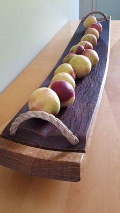 a long wooden tray with apples on it