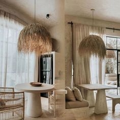 a living room filled with lots of furniture next to a large glass window covered in straw