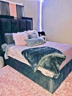 a bed with several pillows on top of it and a blanket over the headboard