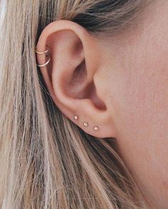 a close up of a person's ear with two piercings on the side