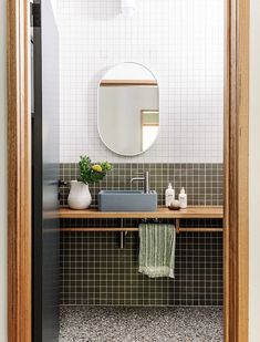 a bathroom with a sink and mirror next to a wall mounted faucet in it