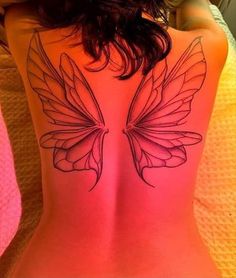 a woman's back with a butterfly tattoo on her lower back and the upper part of her body