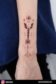 a person with a tattoo on their arm that has an image of a key in it