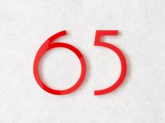 the number fifty five is made out of red plastic and sits on a white surface