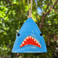 a blue birdhouse with a shark's teeth painted on it