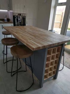 a kitchen island with stools in front of it and an open window to the outside