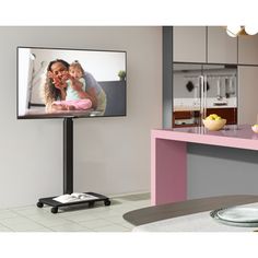 a flat screen tv sitting on top of a pink counter next to a kitchen island