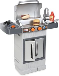 an outdoor gas grill with two burners and three hot dogs on the top shelf