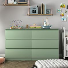 a baby's room with a green dresser and white crib in the foreground