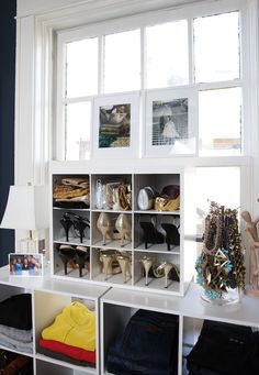 a room that has some shelves and pictures on the window sill in front of it