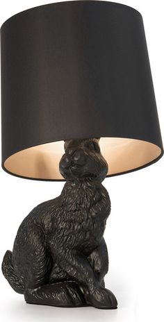 a black rabbit lamp sitting on top of a table next to a black lampshade